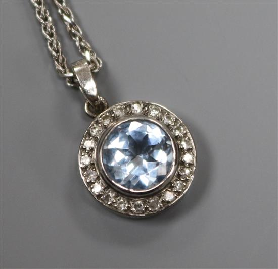 An 18ct white gold, diamond and blue paste circular pendant on 18ct white gold chain.